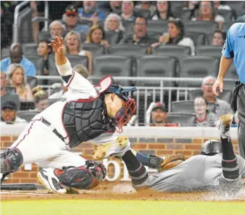  ?? THE ASSSOCIATE­D PRESS ?? Atlanta Braves catcher Kurt Suzuki, left, tags out the Arizona Diamondbac­ks’ Jon Jay sliding into home plate during the sixth inning of Arizona’s 2-1 win Friday night in Atlanta.