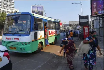  ??  ?? Members of Shri Mahila Griha Udyog alight from a bus to deliver rolled papadums at one of the organisati­on’s facilities in Mumbai.