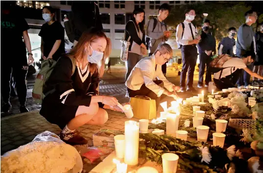  ?? — AP ?? Protesters light candles to pay homage to Chow Tsz-Lok, who fell off a parking garage after police fired tear gas during clashes with anti-government protesters, died in a rare fatality after five months of unrest.