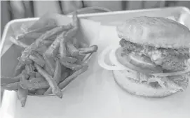  ?? Karen Warren photos / Houston Chronicle ?? Balls Out Burger’s hamburger comes with the option of sweet potato fries.