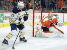  ?? TOM MIHALEK — THE ASSOCIATED PRESS ?? Buffalo center Sam Reinhart, left, controls the puck as Flyers goalie Michal Neuvirth keeps a close watch during the first period Sunday at Wells Fargo Center