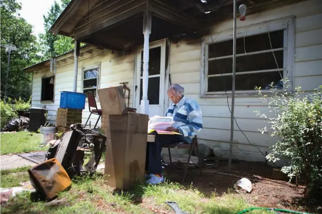  ?? Staff photo by Evan Lewis ?? Helen Dixon looks through files Thursday saved from her burned-out house. Dixon, 92, works part time for the Foreman, Ark., School District, has been an active member of the Foreman community since the 1960s and has been on the Foreman City Council...