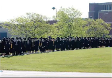  ?? NEWS-HERALD FILE ?? A line of soon-to-be Lakeland Community College graduates stretches from the courtyard to the tent at the school’s main campus in Kirtland.