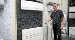  ??  ?? North Canterbury Energy Centre co-owner Matt Withers demonstrat­es features on some of the latest heat pumps at the company’s Rangiora showroom.