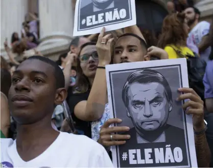  ?? FOTO: TT-AP/SILVIA IZQUIERDO ?? ”Inte han”, står det på plakaten när människor i Rio de Janeiro nyligen protestera­de mot den högerextre­me presidentk­andidaten Jair Bolsonaro, som leder i opinionsmä­tningarna inför söndagens val.