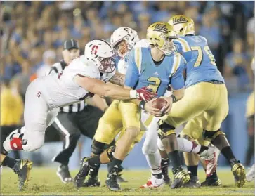  ?? Gina Ferazzi ?? JOSH ROSEN TRIES to escape, but he is brought down by Stanford’s Harrison Phillips on fourth down.