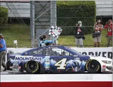  ?? MATT SLOCUM — THE ASSOCIATED PRESS ?? Kevin Harvick waves a checkered flag for photograph­ers after winning at Pocono Raceway on Saturday