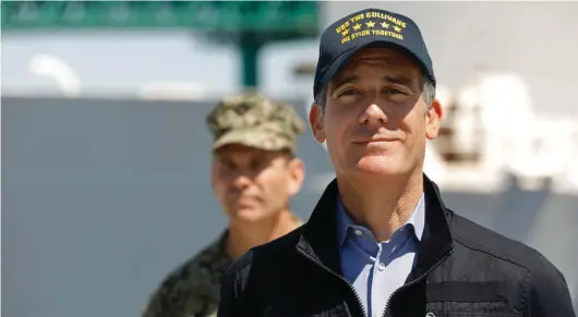  ??  ?? Los Angeles Mayor Eric Garcetti listens as California Governor Gavin Newsom speaks in front of the hospital ship US Naval Ship Mercy that arrived into the Port of Los Angeles on Friday to provide relief for Southland hospitals overwhelme­d by the coronaviru­s pandemic. Admiral John Gumbleton, U.S. Navy stands behind Mayor Garcetti. Photo: AP