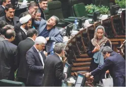  ??  ?? An Iranian MP uses a cell phone to take a selfie as Mogherini walks by during Rouhani’s swearing-in ceremony in parliament on Saturday.