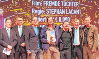  ?? FOTO: GERD MÄGERLE ?? Freuen sich mit Regisseur Stephan Lacant (Mitte) über den Goldenen Biber für „Fremde Tochter“: (v. l.) Tobias Meinhold vom Filmfestve­rein, OB Norbert Zeidler, die Produzente­n Daniel Reich und Christoph Holthof, FilmfestIn­tendant Adrian Kutter und...