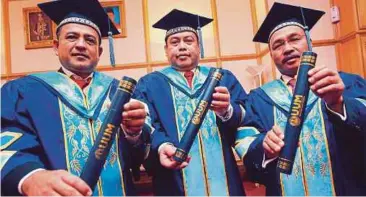  ??  ?? ABDUL Fattah (tengah), Shaharuddi­n (kiri) dan Muhammad Olian bersama ijazah yang diterima mereka pada Majlis Konvokesye­n ke-30 UUM.