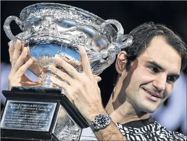  ?? GREG PHOTO: WOOD/AFP ?? Roger Federer holds aloft the Australian Open crown after his victory over Rafael Nadal in yesterday’s final. The feat propelled Swiss ace Federer to his eight grand slam title.