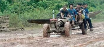  ??  ?? Residents returning to their homes from Sanamxai district after floodwater­s from a dam collapse had receded. — AFP