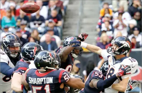  ?? DAVID J. PHILLIP / ASSOCIATED PRESS ?? Denver Bronco Peyton Manning is hit by Houston Texan Joe Mays as he throws during the third quarter of their game on Sunday in Houston. Manning threw his 51st touchdown pass of the season to set a new NFL record.