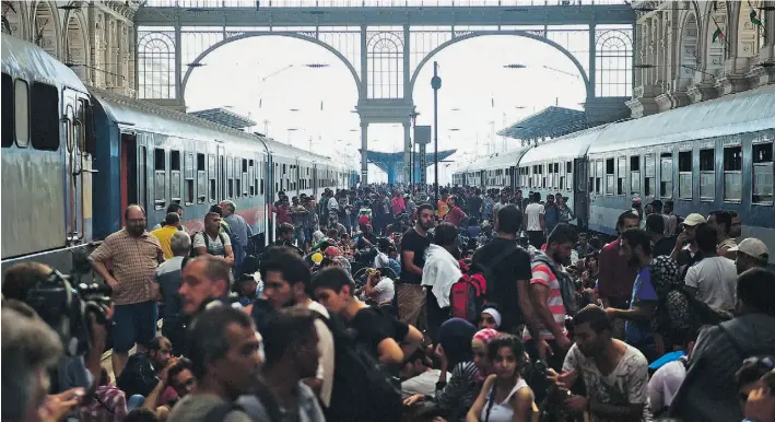  ?? ATTILA KISBENEDEK/AFP/ GETTY IMAGES ?? Migrants and refugees crowd the platforms at the Keleti train station in Budapest on Tuesday. Human rights activists criticized Hungary’s move to block asylum seekers from its trains.