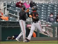  ??  ?? The Giants’ Donovan Solano, right, celebrates his two-run home run against the Indians with third base coach Ron Wotus.