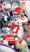  ?? AP PHOTO ?? Kansas City Chiefs running back Kareem Hunt (27) is tackled by New England Patriots defenders during the first half of an NFL football game on Sunday in Foxborough, Mass.