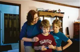  ?? Laura McDermott / New York Times ?? Celine Ryan, who had advanced colon cancer, at home with sons Decklan, center, and Liam in Rochester Hills, Mich., is now cancer-free thanks to a new form of immunother­apy, which enlists her own immune system to fight the disease.