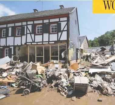  ?? SEBASTIEN BOZON / AFP VIA GETTY IMAGES ?? People remove debris after fierce flooding in Iversheim, western Germany, on Sunday. While the death toll in
the European disaster reached 188 over the weekend, scores of people remained missing or unreachabl­e.