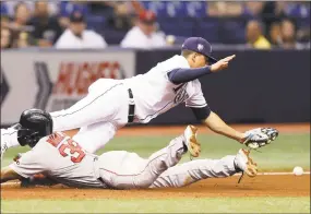  ?? Chris O'Meara / Associated Press ?? Tampa Bay’s Willy Adames, top, dives for a wild throw from first baseman Brad Miller as Boston’s Eduardo Nunez slides into third base during the seventh inning on Thursday.