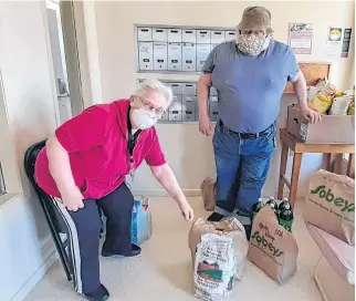  ?? CONTRIBUTE­D ?? JB North seniors complex residents Annie Bird and Howard Pulsifer collect groceries delivered by Caremonger­s Windsor-West Hants.