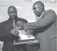  ??  ?? Zimpapers Digital and Publishing Division Financial Manager Mr Godwin Takundwa (left) receives a trophy and a shield from Mr Dzingirai Tusai for Best Exemplary Leadership Award at the Megafest Business Awards ceremony