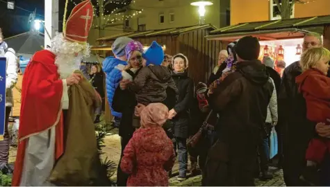  ?? Fotos: Heike Scherer ?? Auf dem Meringer Weihnachts­markt war auch Sankt Nikolaus zu Gast und beschenkte die Kinder mit Überraschu­ngen aus seinem Sack.