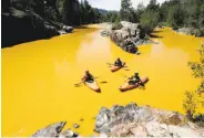  ?? Jerry McBride / Associated Pres 2015 ?? Kayakers paddle in water colored from a 2015 mine spill in the Animas River near Durango, Colo.