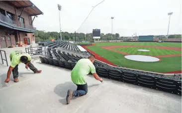  ?? MIKE DE SISTI/ MILWAUKEE JOURNAL SENTINEL ?? David Silva, left, and Jesse Pierringer of Sid’s Sealants of Port Washington seal concrete at the new ABC Supply Stadium in Beloit on Wednesday. The baseball stadium, home of the Beloit Snappers, is set to open Tuesday.