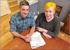  ?? GILLIAN FLACCUS/AP PHOTO ?? Husband and wife Andy Kraft and Amy Elias, of Portland, Ore., pose with their 2018 tax paperwork in their Portland home. The couple got a small refund last year but this year owe more than $10,000 in taxes under the new tax law.