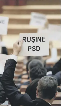  ??  ?? 0 A Romanian MP holds a sign saying ‘shame, PSD’ as the ruling party staged a victorious no-confidence motion in its own premier