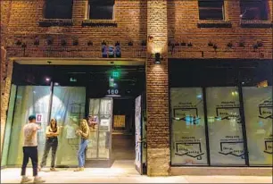  ?? ?? PEOPLE wait outside the Groundf loor in Echo Park. The club’s founder says its co-working space, fitness classes and curated events make the $200 monthly cost a pretty good deal.