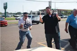  ?? Staff photo by Kelsi Brinkmeyer ?? John Harbison cheers alongside The Texas Bucket List host Shane McAuliffe as he scores a third hole in a giant cornhole game setup outside Dairy Queen in Wake Village Thursday afternoon. McAuliffe helf a meet and greet giving away Dairy Queen merch and ice cream to attendees.