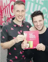  ??  ?? Juice Truck founder-owners Zach Berman and Ryan Slater show the 232-page book that appears to leave no fruit or vegetable unsqueezed.