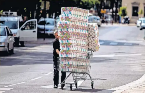  ?? EFE ?? Un reponedor traslada un carro de papel higiénico a un comercio en el centro de Málaga.