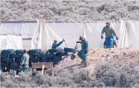  ?? EDDIE MOORE/JOURNAL ?? The Taos County Sheriff’s Office and the FBI use shovels to search a compound near the Colorado border in August.