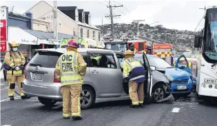  ?? PHOTO: PETER MCINTOSH ?? Assistance . . . Emergency services attend a crash in Hillside Rd yesterday.