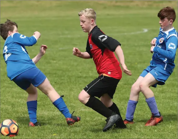  ?? Picture: Paul Connor ?? Drogheda Town’s Patrick Keane finds a way through Slane Wanderers’ Oisin Mooney and David Kavanagh during the Under-12 League match at St Oliv er’s Community College.