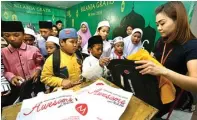  ?? AHMAD KHUSAINI/JAWA POS ?? AMBIL YANG DISUKA: Anak-anak panti asuhan dipersilak­an memilih baju dan tas gratis di Pasar Atom kemarin.