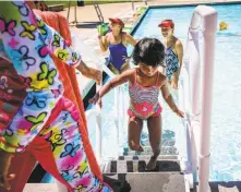  ?? Gabrielle Lurie / The Chronicle ?? Sisters Kriya Daniel, 3 (center), and Diyah Daniel, 8, climb out of the pool after Diyah’s swimming lesson at the Clarke Swim Center in Walnut Creek. Temperatur­es set heat records on the weekend.