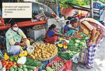  ??  ?? Vendors sell vegetables
■ at roadside stalls in Kolkata. AP