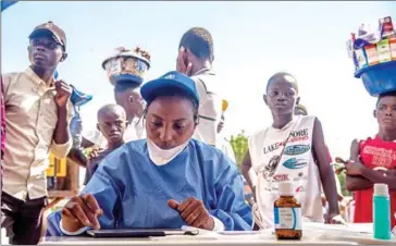  ?? JUNIOR KANNAH/AFP ?? Nurses working with the World Health Organizati­on (WHO) prepare to administer vaccines at the town all of Mbandaka, in DR Congo, on Monday during the launch of the Ebola vaccinatio­n campaign.