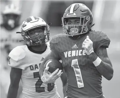  ?? MICHAEL LAUGHLIN/SUN SENTINEL ?? Venice receiver Jayshon Platt runs towards the end zone in front of Apopka defender Antwone Robinson in the 2021 Class 8A football state championsh­ip game in Fort Lauderdale. The teams would be in separate divisions under a proposal that is being considered by the FHSAA.