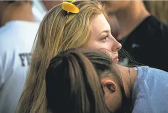  ?? DOROTHY EDWARDS/ NAPLES DAILY NEWS ?? People mourn during a candleligh­t vigil Wednesday after a shooting at Marjory Stoneman Douglas High School in Parkland, Fla.