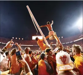  ?? WADE PAYNE — THE ASSOCIATED PRESS ?? Tennessee fans storm the field and tear down the goal post after the Volunteers defeated Alabama 52-49on Saturday. The wild celebratio­n left the school with a $100,000fine.