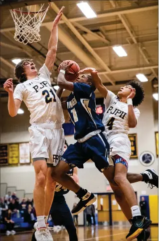  ?? JAMES BEAVER/FOR MEDIANEWS GROUP ?? Upper Merion’s Madison Tatom (11) is met with heavy resistance under the net from Pope John Paul II’s Justin Green (21) and Jaden Workman (4) on Thursday night.