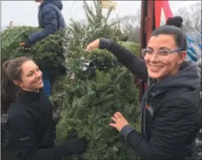  ?? PAUL POST — DIGITAL FIRST MEDIA ?? Army National Guard Staff Sergeant Shannon Schiller, left, and Ellms Family Farm employee Jen Hotaling, right, help with a Trees for Troops collection effort on Monday.