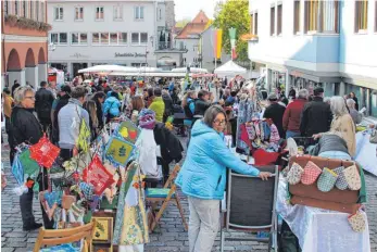  ??  ?? Ein wahrer Besucherma­gnet: Der vierte Leutkirche­r Koffermark­t (Bild links). Die Kinder genießen währenddes­sen eine Fahrt auf dem Karussell.