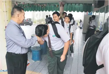  ??  ?? Students seek blessing from Bujang before entering the examinatio­n hall.