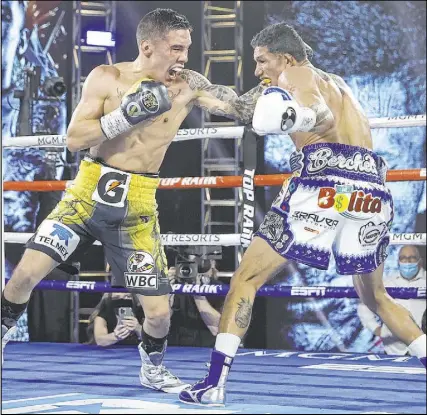  ?? Mikey Williams Top Rank Inc via Getty Images ?? Oscar Valdez, left, knocked out Miguel Berchelt with a left hook in the 10th round to win the WBC super featherwei­ght title inside the MGM Grand’s Grand Ballroom.